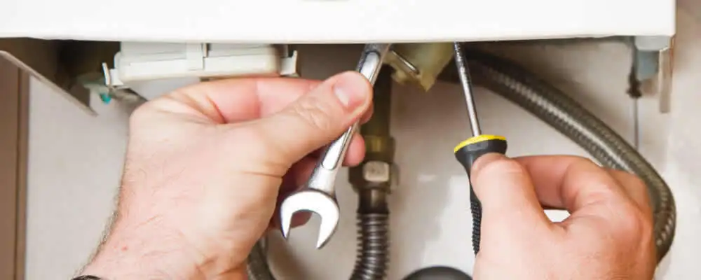 Boiler repair technician tightening pipe fittings and connections in Lynchburg, VA
