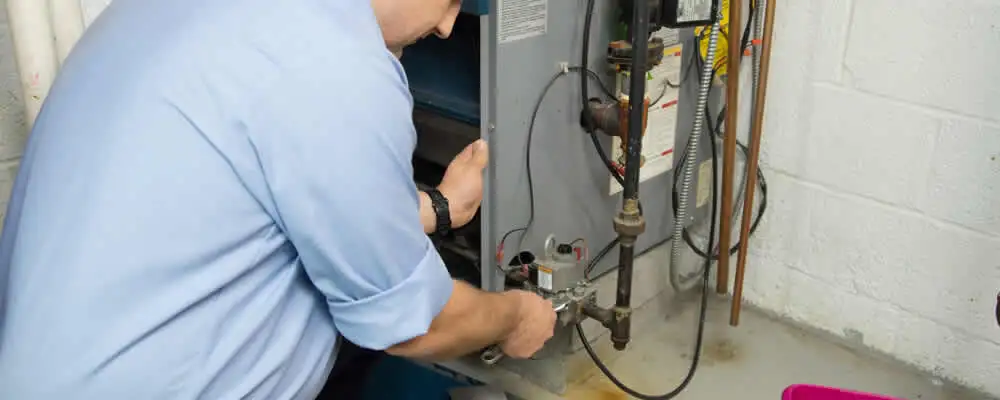Furnace repair technician inspecting and servicing a home heating system in Lynchburg, VA