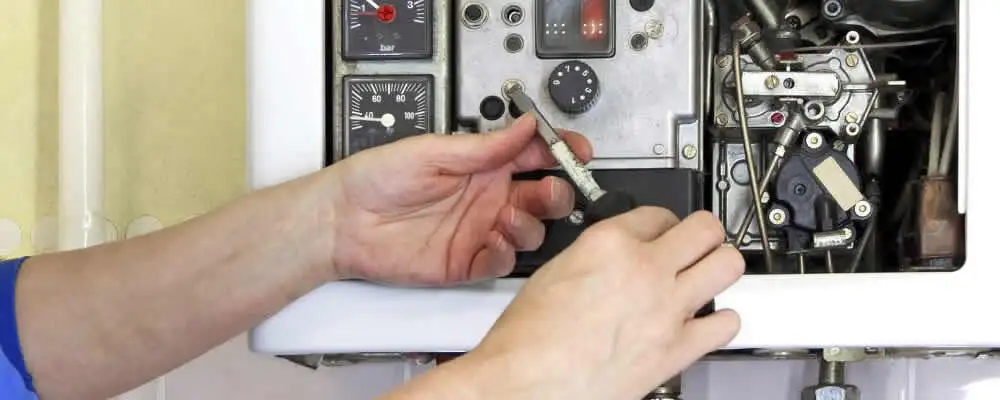 Heating repair technician adjusting boiler controls and components in Lynchburg, VA