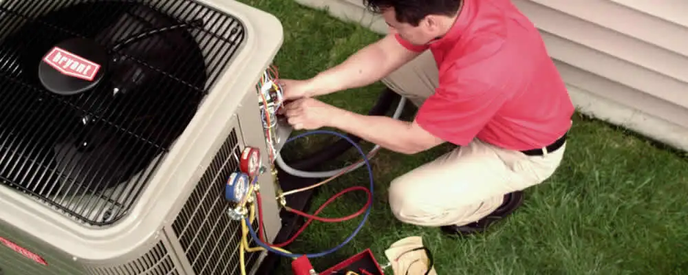 HVAC technician servicing an outdoor air conditioner unit in Lynchburg, VA