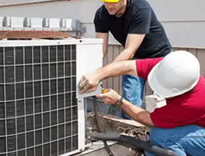 HVAC technicians repairing an outdoor AC unit on a rooftop in Lynchburg, VA