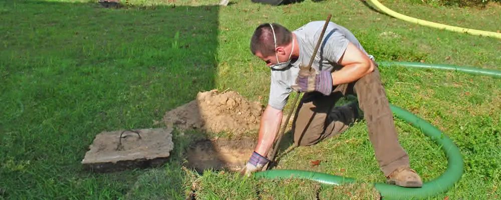 Septic pumping technician servicing a residential septic tank in Lynchburg, VA