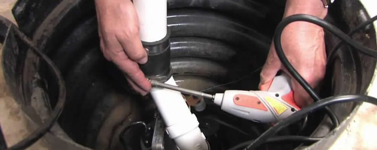 Sump pump installation technician connecting PVC discharge piping in Lynchburg, VA