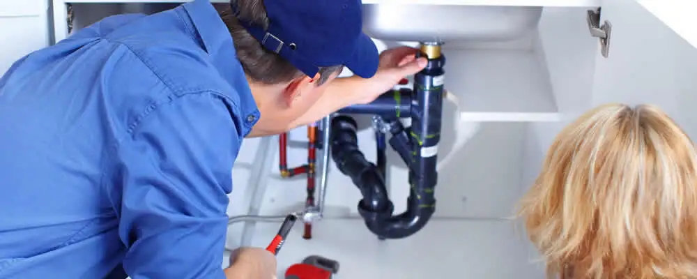 Plumber repairing under-sink drain pipes and fittings in Lynchburg, VA